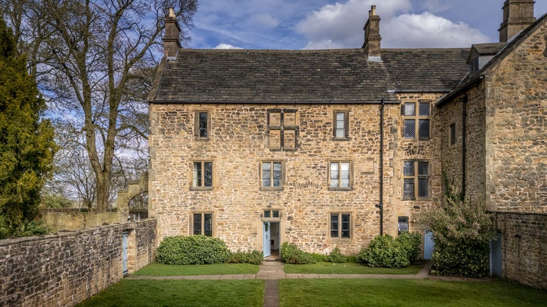 The exterior of 6 High Hazels, a three-storey stone cottage, Derbyshire